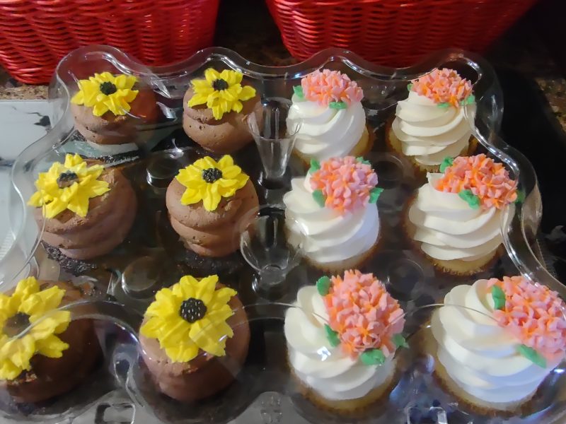 chocolate cupcakes with chocolate buttercream decorated with buttercream sunflowers. vanilla cupcakes with chocolate frosting vanilla buttercream frosting decorated with buttercream frosting pink pansies
